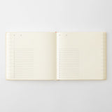 An open cream-colored diary with lined pages, photographed flat against a light gray background.