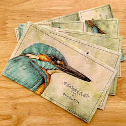 Stack of cards with a bird illustration on a wooden surface