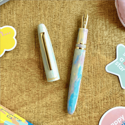 Fountain pen with gold accents on a textured surface with decorative elements
