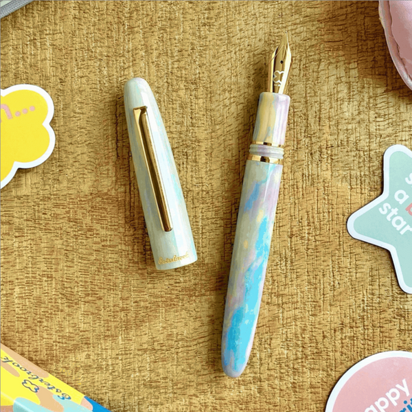 Fountain pen with gold accents on a textured surface with decorative elements