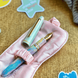 Fountain pen set with pink case on a textured surface