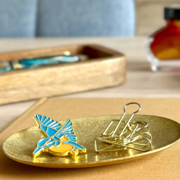 Kingfisher Pin and gold clips on a gold tray with a blurred background