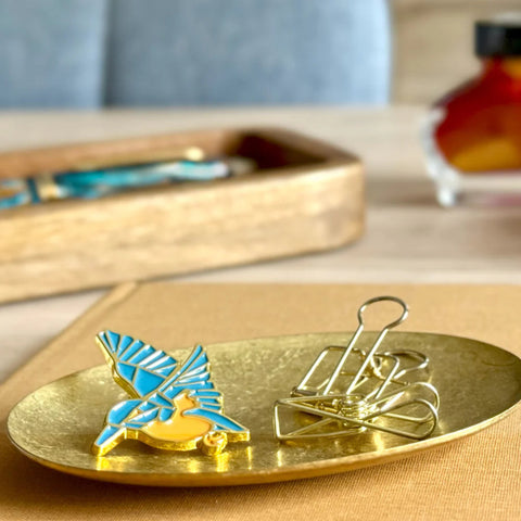 Kingfisher Pin and gold clips on a gold tray with a blurred background