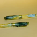 Two green and yellow pens on a beige background