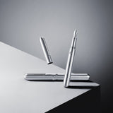 Two silver pens on a reflective surface with a gradient gray background